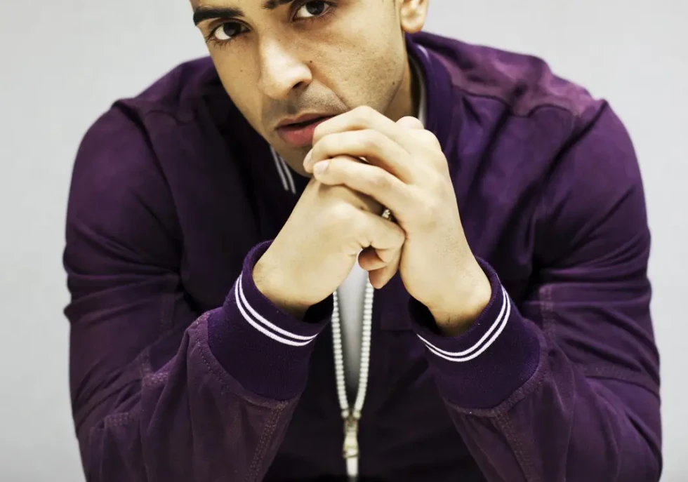 Jay Sean in a purple jacket, seated for a portrait